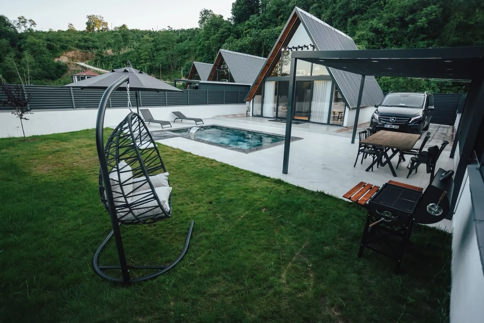Bahçedeki salıncak koltuk ve pergola altındaki oturma alanı